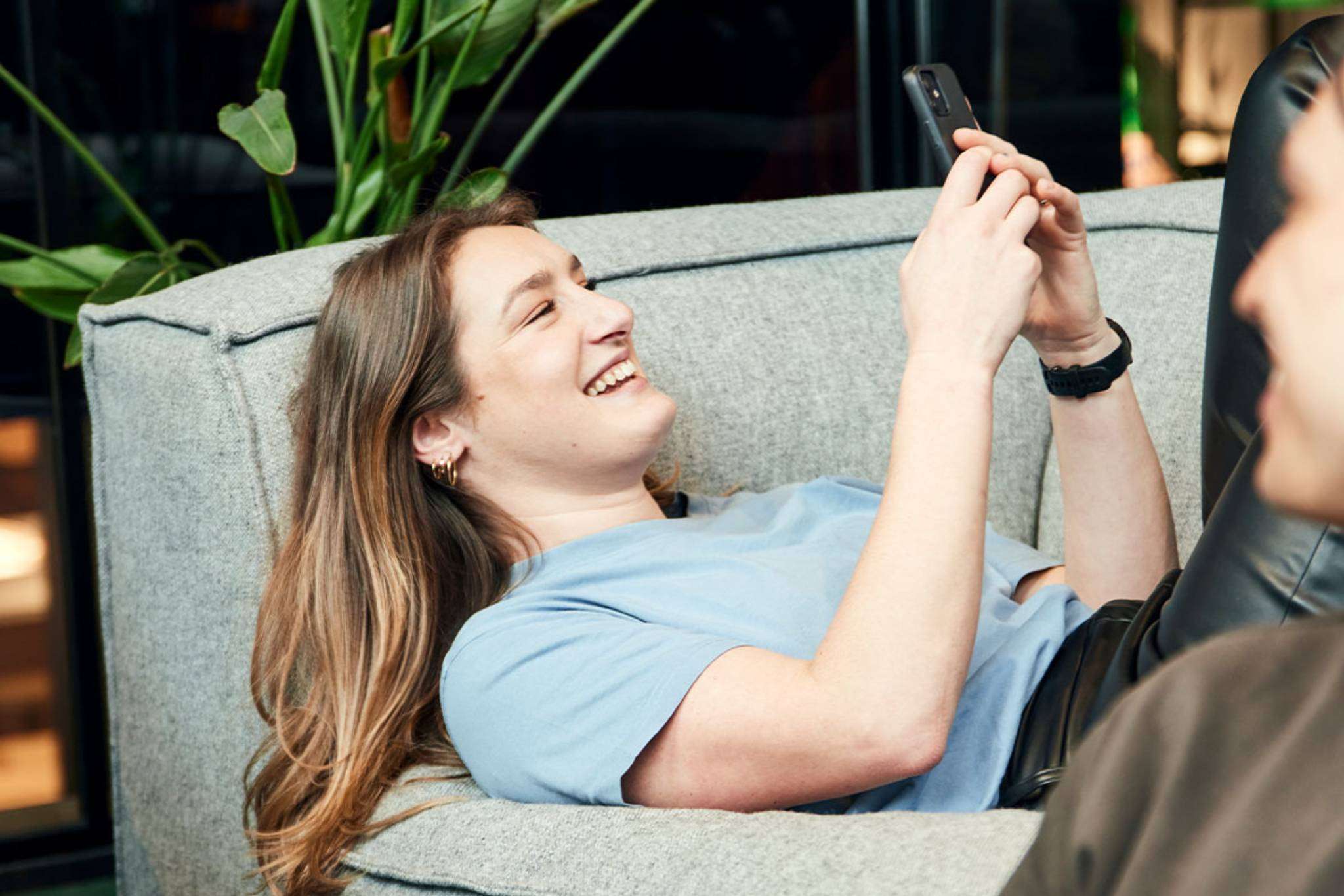 vrouw-lacht-telefoon-chill-bank