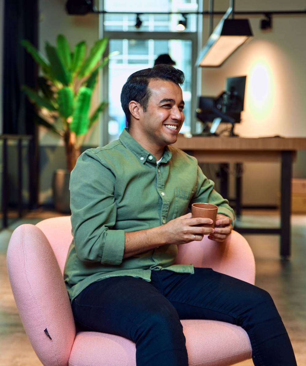 jongen-lacht-koffie-roze-stoel