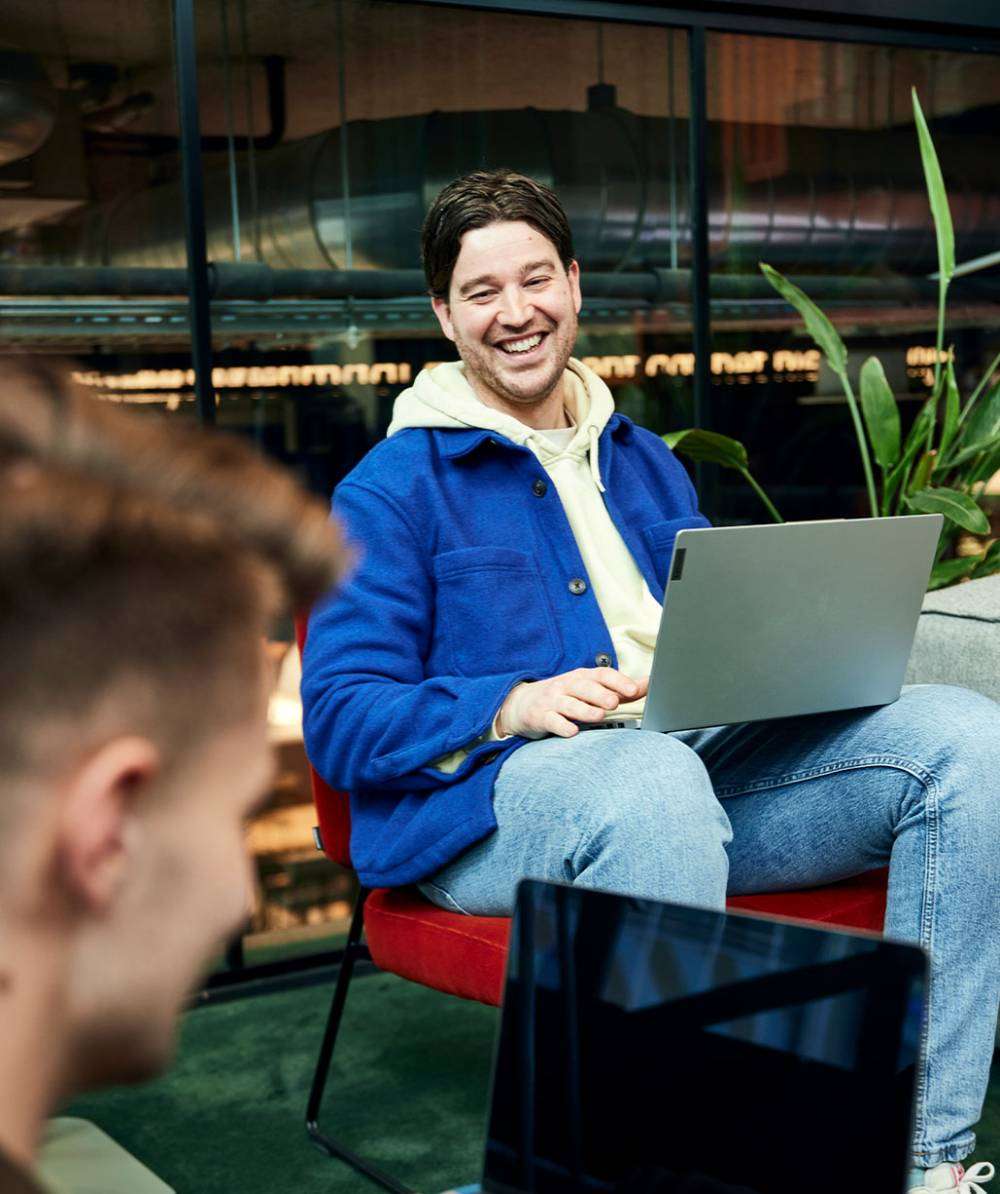 man-laptop-lachen-samenwerken