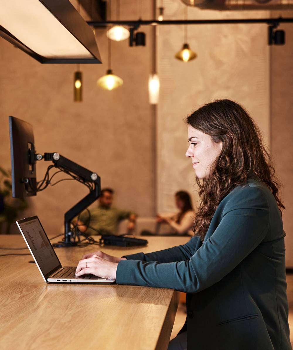 vrouw-zijwaards-hoge-tafel-laptop-werken
